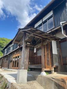 a building with wooden doors and windows on a mountain at イヤシロチomoya in Onomichi