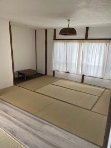 a room with three mats in front of a window at イヤシロチomoya in Onomichi