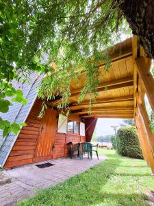 een gebouw met een tafel en stoelen ervoor bij Domek Letniskowy Łętowo in Łętowo