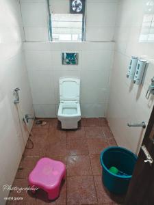 a small bathroom with a toilet and a bucket at RK Hotel in Boisar