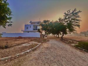 una casa su una strada sterrata con alberi di fronte di Mangal Uday Villa a Jaipur Altre 18 foto