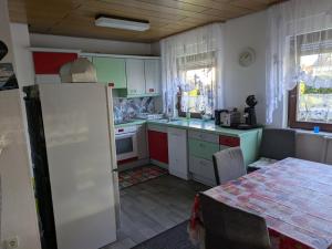 eine Küche mit einem weißen Kühlschrank und einem Tisch in der Unterkunft Gabis' Apartment in Bad Wimpfen