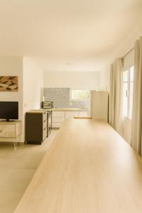 una cucina con pavimento in legno e frigorifero di Departamento LUNA NUEVA a Santa Clara del Mar