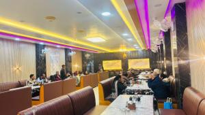 un gruppo di persone sedute ai tavoli di un ristorante di Ananya Hotel and Restaurant Naimisharanya a Naimishāranya