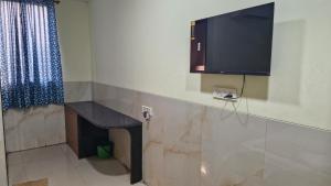 a living room with a fireplace and a tv on the wall at RK Hotel in Boisar