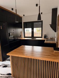 a kitchen with black cabinets and a wooden counter top at Willa Rytel in Rytel