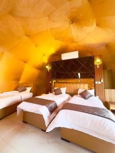 twee bedden in een kamer met een geel plafond bij Princess luxury camp in Wadi Rum +79 foto's