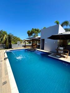 a swimming pool in front of a house at Residencial Rocha - Praia de Guaratiba - Prado - Ba in Prado