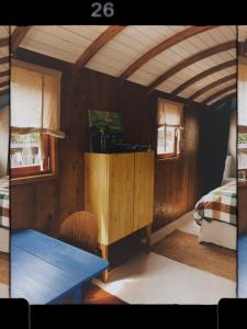 a room with a bedroom with a table and a bed at Tuiny House Noordwijk in Noordwijk