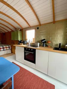 a kitchen with white cabinets and a counter top at Tuiny House Noordwijk in Noordwijk