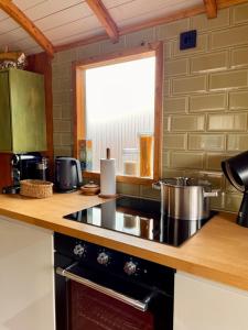 a kitchen with a stove and a counter top at Tuiny House Noordwijk in Noordwijk +15 photos