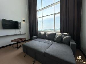 a living room with a couch and a large window at Metra Square Ayer Keroh MITC in Ayer Keroh