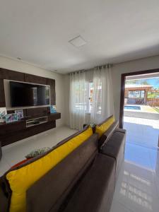 a living room with a large couch and a television at Residencial Rocha - Praia de Guaratiba - Prado - Ba in Prado