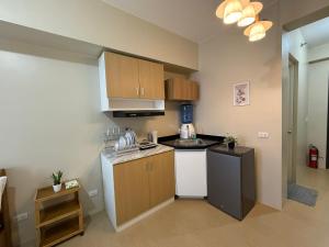a small kitchen with a stove and a refrigerator at Oregano Suite- Avida Towers Aspira 2 in Sampong