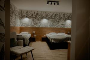 una stanza con tre letti e una sedia di Gościniec Paradise a Mierzęcice Altre 51 foto