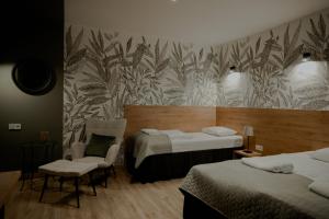 una stanza d'albergo con due letti e una sedia di Gościniec Paradise a Mierzęcice