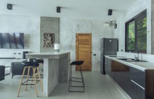 eine Küche mit einer Theke und Hockern darin in der Unterkunft Eskobar Villa Exclusive in Baan Tai
