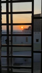 a view of the sunset through a window at Khách sạn Nhất Phương 2 in Ấp Ðông An (1) +24 photos