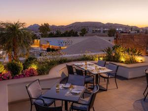 a restaurant with tables and chairs on a roof at Mövenpick Resort Petra in Wadi Musa