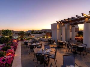a restaurant with tables and chairs on a patio at Mövenpick Resort Petra in Wadi Musa