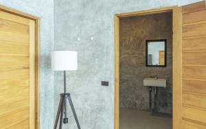 ein Badezimmer mit einem Waschbecken, einer Lampe und einem Spiegel in der Unterkunft Eskobar Villa Exclusive in Baan Tai + 25 Fotos