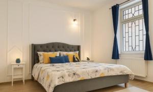 a bedroom with a bed with blue curtains and a window at Sweet cozy studio ultracentral in Cluj-Napoca +7 photos