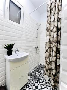 a white bathroom with a sink and a shower curtain at Sweet cozy studio ultracentral in Cluj-Napoca