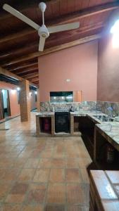ein großer Raum mit einem Steinkamin und einem Deckenventilator in der Unterkunft Casa Quinta Elena in San Lorenzo