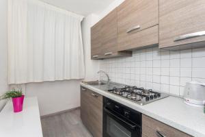 una cucina con lavello e fornello forno superiore di Domus Elisae - Taormina a Taormina