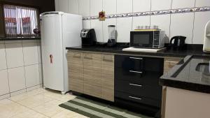 una cucina con frigorifero e forno a microonde di Casa com piscina bem localizada a Anápolis Altre 9 foto
