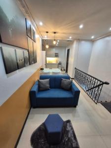 a living room with a blue couch and a table at Layover at 1146 in Manila