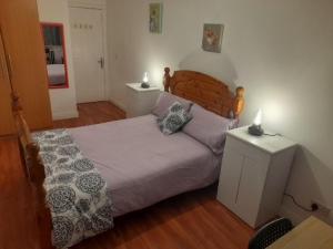 a bedroom with a bed and a table with a lamp at Double room beside tramline in Dublin