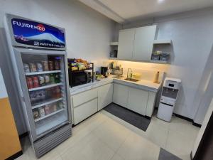 a small kitchen with a refrigerator with drinks in it at Layover at 1146 in Manila