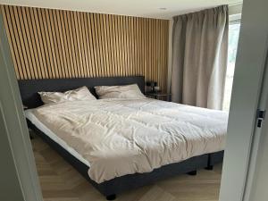 a bedroom with a bed with white sheets and a window at Sustainable Stay by Palette Resort de-Steppe in Ulicoten