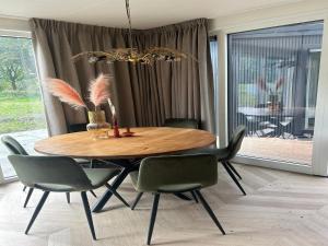 a dining room with a wooden table and chairs at Sustainable Stay by Palette Resort de-Steppe in Ulicoten