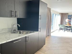 a kitchen with a sink and a table with chairs at Sustainable Stay by Palette Resort de-Steppe in Ulicoten +20 photos
