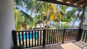 a balcony with a view of the beach and palm trees at Beach House at Kokrobite in Kokrobite +5 photos