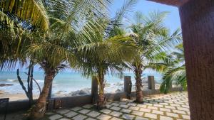 a view of a beach with palm trees and the ocean at Beach House at Kokrobite in Kokrobite