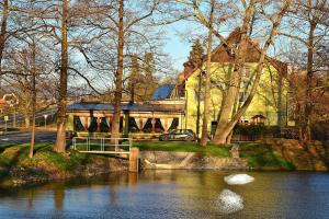 a house with a bridge over a river with a car at MOTOREST-PENSION U HRACHŮ,s.r.o. in Klatovy