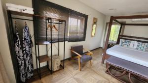 a bedroom with a bed and a chair in it at Beach House at Kokrobite in Kokrobite