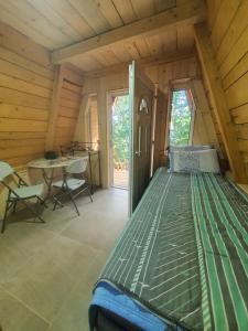 a bedroom in a log cabin with a bed and a table at Tri breze in Kolašin