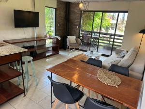 een woonkamer met een bank, een tafel en stoelen bij Los Pecados de la Viuda in Punta Del Diablo