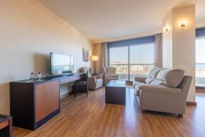 a living room with a tv and a couch and a chair at Moon Dreams Calabahía in Cala del Moral