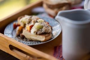 a plate with two hot dogs on a wooden tray at Crepúsculo Serrano in Merlo