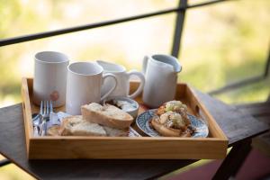a wooden tray of food with sandwiches and coffee cups at Crepúsculo Serrano in Merlo +15 photos