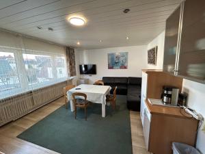 a living room with a table and a kitchen with a couch at Apartment am Rathaus 3SZ in Rödermark