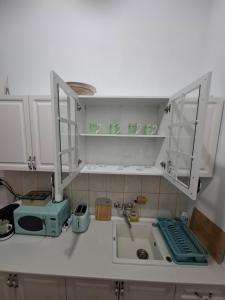 a kitchen counter with white cabinets and a sink at Art Nouveau Aparthotel in Oradea +30 photos