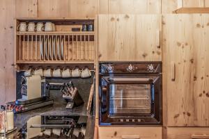 een keuken met houten kasten en een kookplaat met oven bij Chalet Bauernhaus 1864 in Elbigenalp