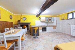 a kitchen and living room with yellow walls at Al Rifugio Nel Borgo in Vitorchiano