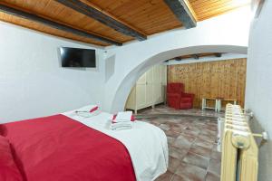 a bedroom with a red bed and a red chair at Al Rifugio Nel Borgo in Vitorchiano